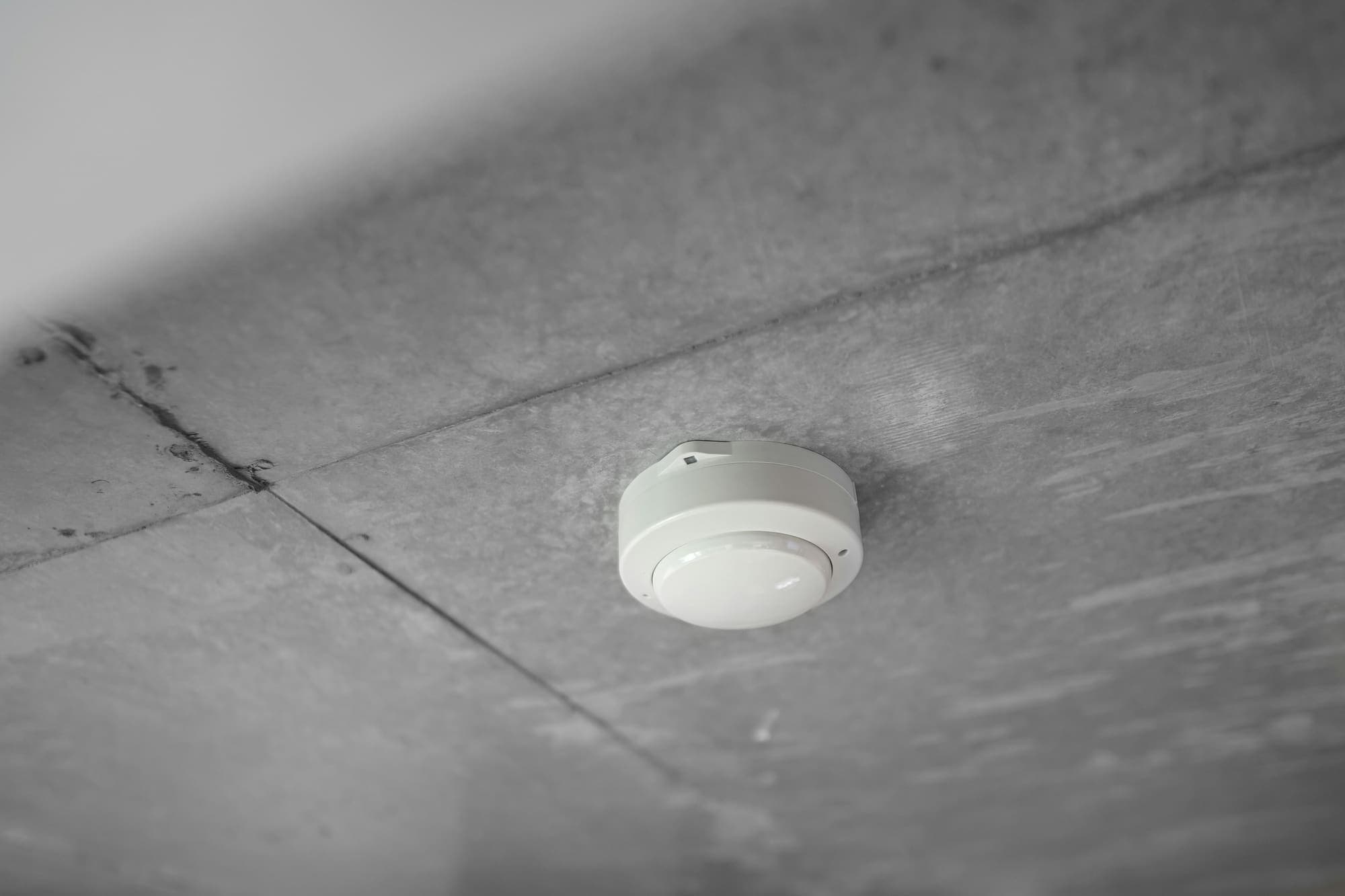 Ceiling-mounted fire detector on a concrete slab ceiling